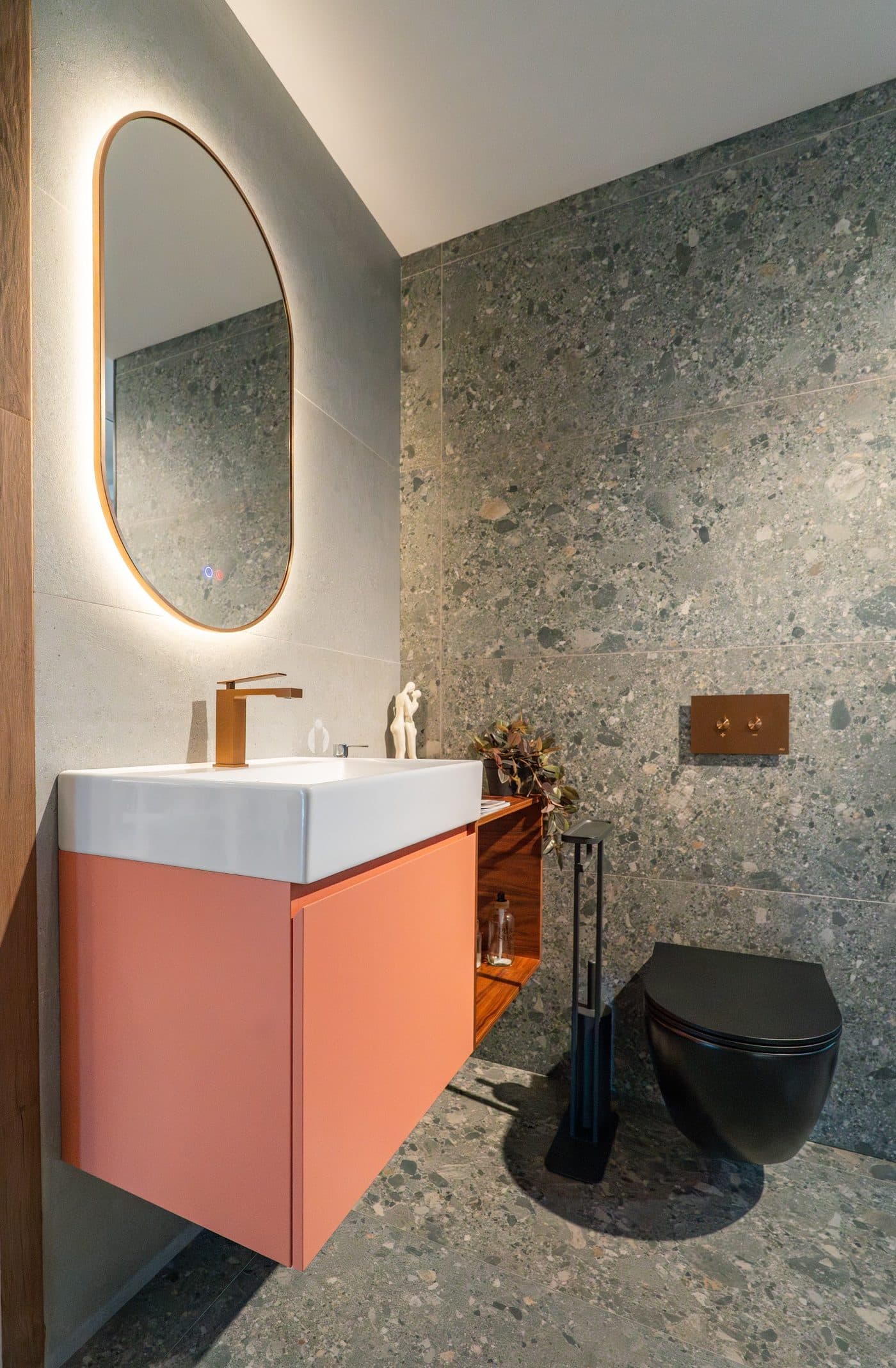 Parede em terrazzo com móvel suspenso e espelho oval